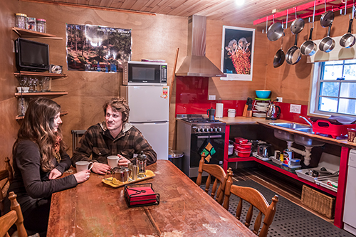 Young couple sitting in the kitchen of the Settlers Hut